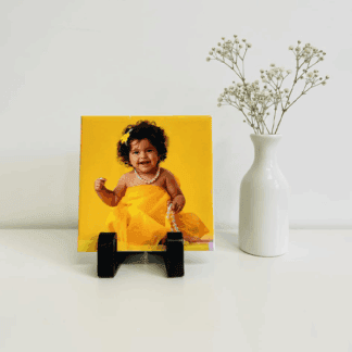 Custom photo tile with display stand showcasing a smiling child's portrait.